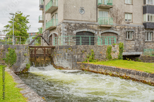 Middle River with water flowing into the lock at Fisherman’s Wharf on the east side of the Corrib River, Waterways of Galway, cloudy day in Galway City, Connacht province, Ireland