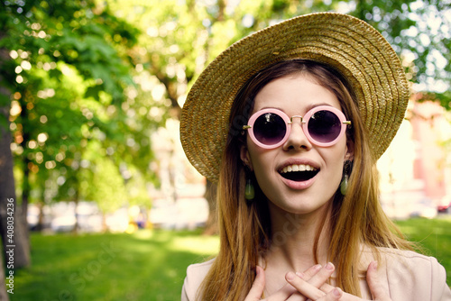 Pretty woman in sunglasses and a hat outdoors in the park rest