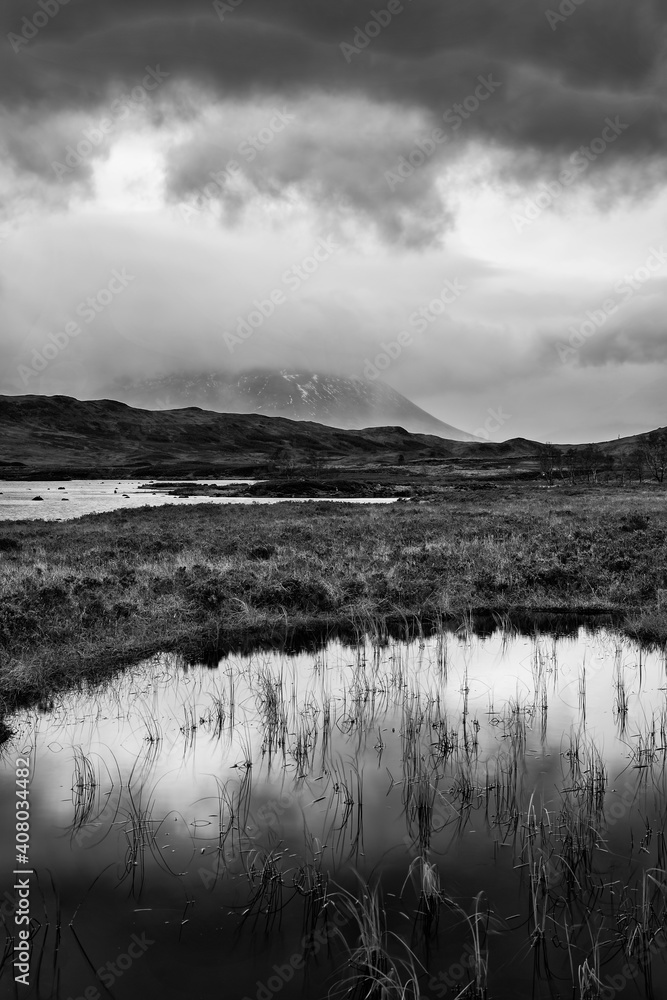 Epic dramatic  black and white landscape image of Loch Ba on Rannoch Moor in Scottish Highlands on a Winter morning