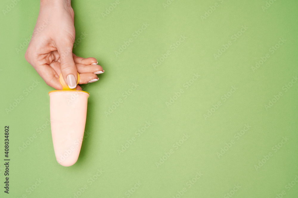Beautiful Female well-groomed Hands with French manicure over green background Beautiful Female well-groomed Hands with French manicure over green background