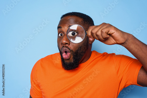 Man search something with a magnifier lens with surprised expression