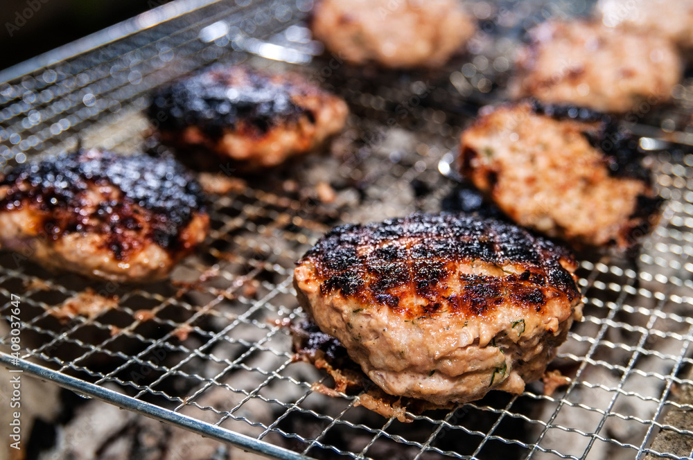 Closeup of burnt pork burger patties on BBQ pit grill Closeup of burnt pork burger patties on BBQ pit grill