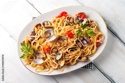 Fototapeta Naklejka Na Ścianę i Meble -  Vassoio di deliziose linguine con vongole, pomodorini e prezzemolo, cucina Italiana 