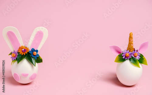 Easter eggs unicorns and rabbit on a pastel pink background. Copy space. Minimal pink Easter card.