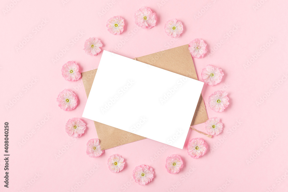 Blank greeting card in frame made of pink cherry blossoming flowers on pastel pink background. Flat lay. Mock up Blank greeting card in frame made of pink cherry blossoming flowers on pastel pink background. Flat lay. Mock up