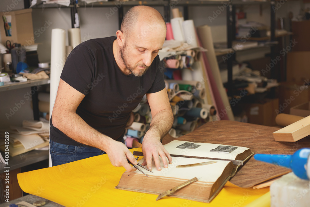 book binder restores old book in craft workshop book binder restores old book in craft workshop