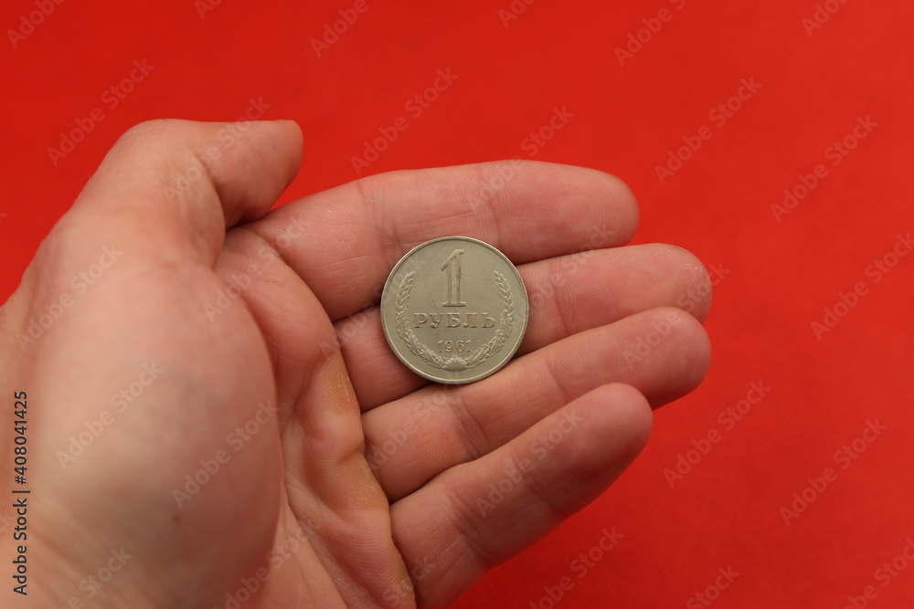 The soviet coin ruble in hand on red background The soviet coin ruble in hand on red background