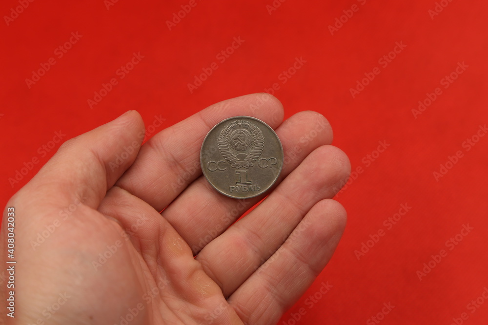 The soviet coin ruble in hand on red background