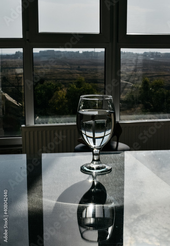 Wine glass with water on a glass table