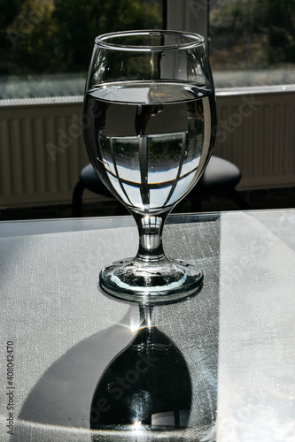 Wine glass with water on a glass table