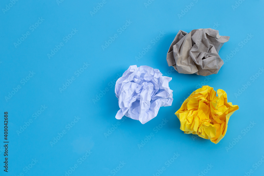 Fototapeta premium Crumpled paper balls on blue background.