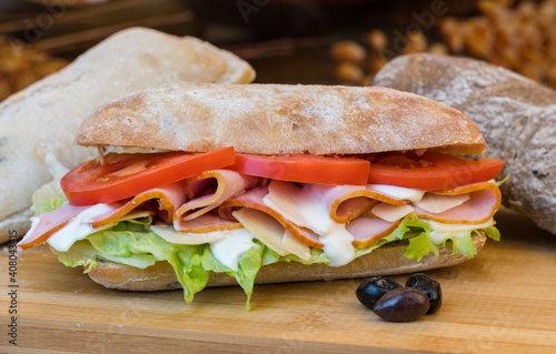 Fresh made ingredients inside ciabatta rolls on wooden surface