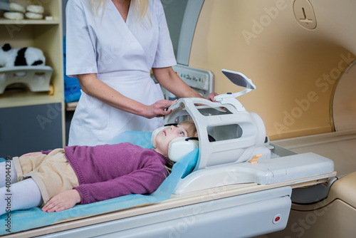 Radiologist prepares the little girl for an MRI brain examination