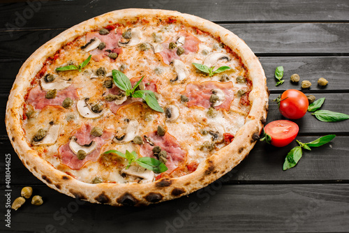 Tasty fresh pizza with ingredients on wooden background