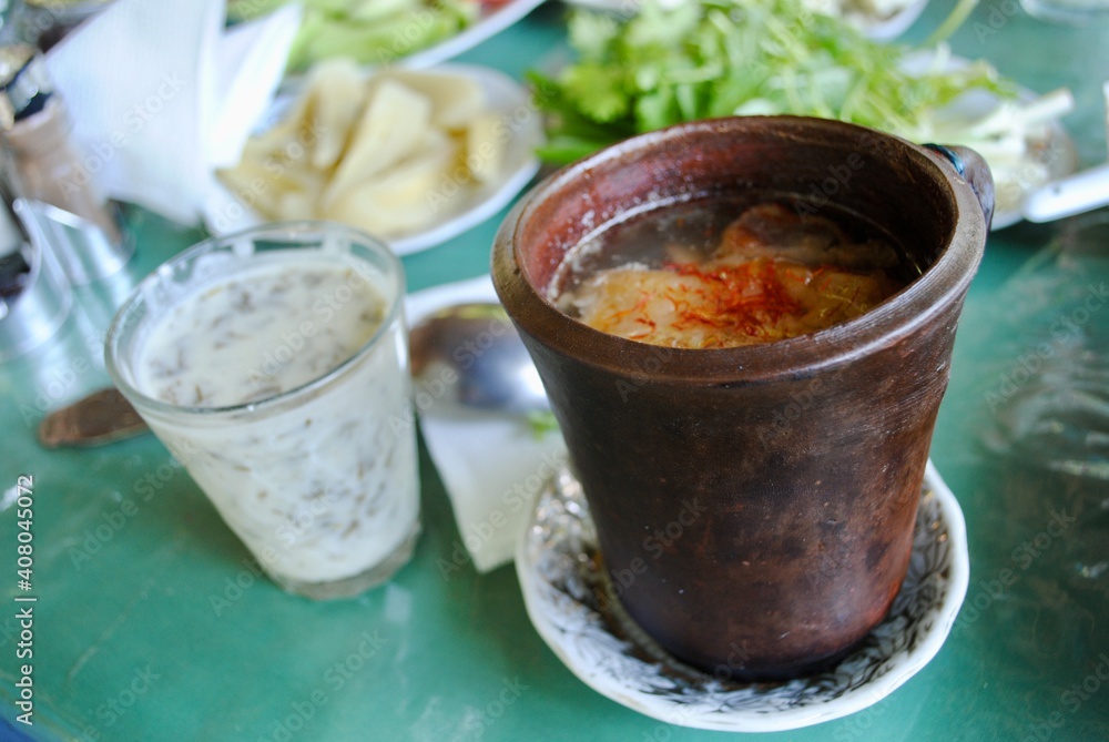 Piti, Azerbaijani Sheki or Shaki, soup prepared with mutton, tail fat, chickpeas, potato, onions, dried plum, saffron and cooked in earthenware pot. Eat with mint yogurt. Selective focus. Piti, Azerbaijani Sheki or Shaki, soup prepared with mutton, tail fat, chickpeas, potato, onions, dried plum, saffron and cooked in earthenware pot. Eat with mint yogurt. Selective focus.