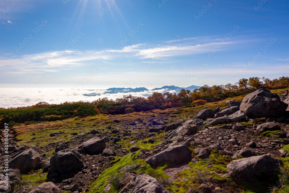 秋の北海道・大雪山系の赤岳で見た、山肌に迫りくる雲海と快晴の青空