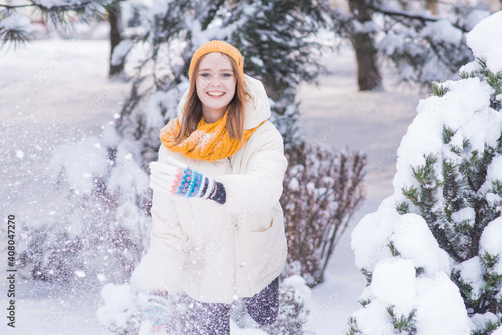 Fototapeta premium Portrait of a happy smiling girl on a snowy winter day
