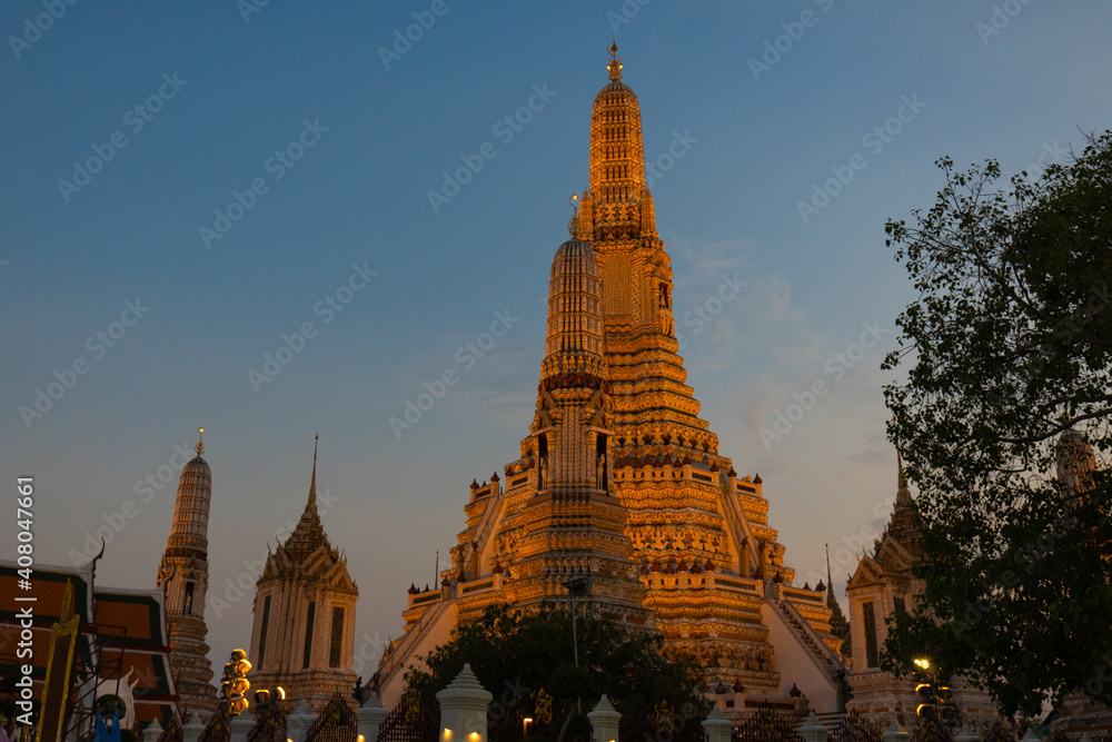 Illuminated Wat Arun Temple in sunset. Buddhist temple in Bangkok, Thailand