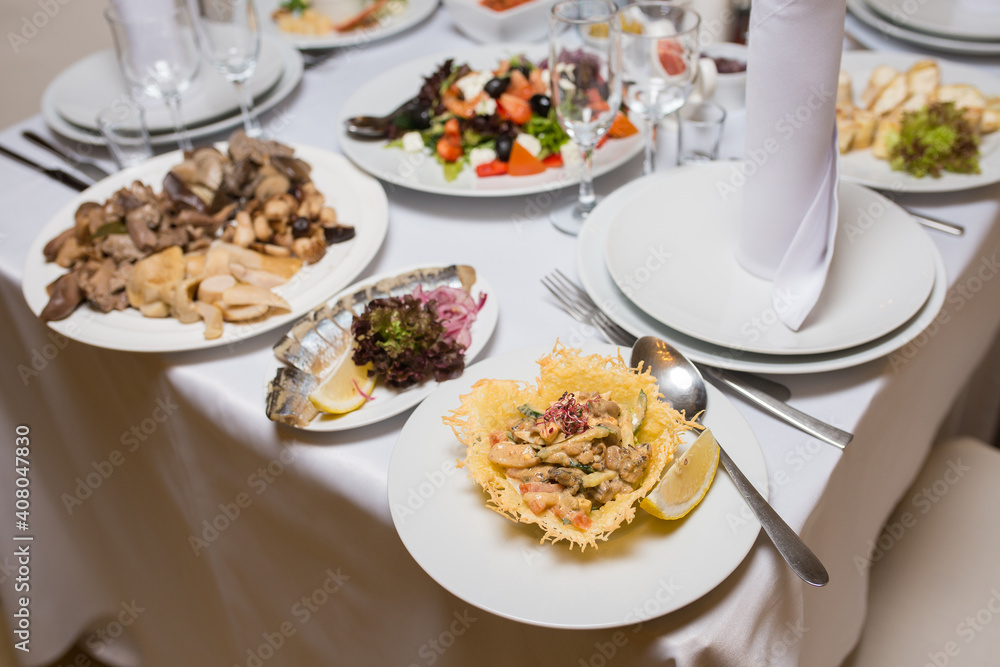 Plates with ready meals on the served restaurant table Plates with ready meals on the served restaurant table
