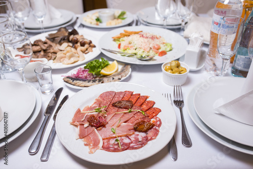 Plate with cold cuts on the server table of the restaurant