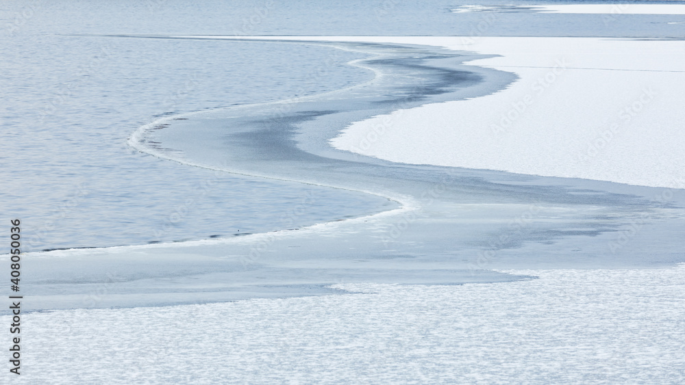 Partially frozen lake surface and snow