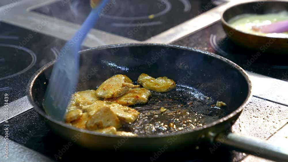 Close up of frying in pan. Chef cooking food in large pan at restaurant