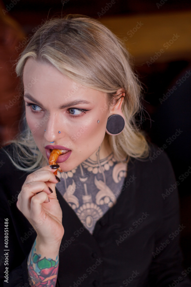 A portrait of a girl of Slavic appearance who eats deep-fried shrimp. A portrait of a girl of Slavic appearance who eats deep-fried shrimp.