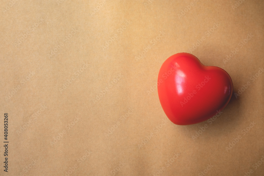 Red heart on brown paper background. Symbol of support that expresses love valentine day and world heart day, heart health concept Red heart on brown paper background. Symbol of support that expresses love valentine day and world heart day, heart health concept