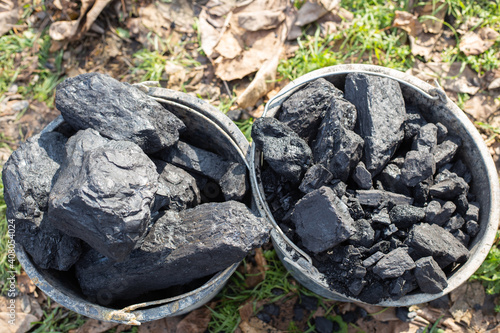 Large chunks of coal in buckets. Procurement of fuel for the winter. Heating of houses in the countryside
