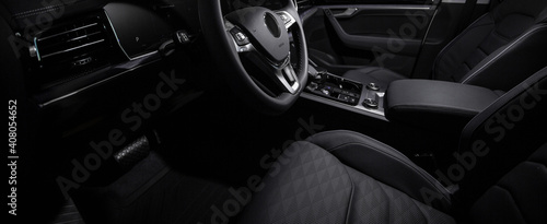 Luxury car black interior. Steering wheel, shift lever and dashboard. 