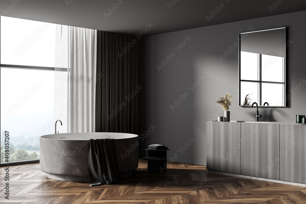Dark gray bathroom corner with round tub and sink