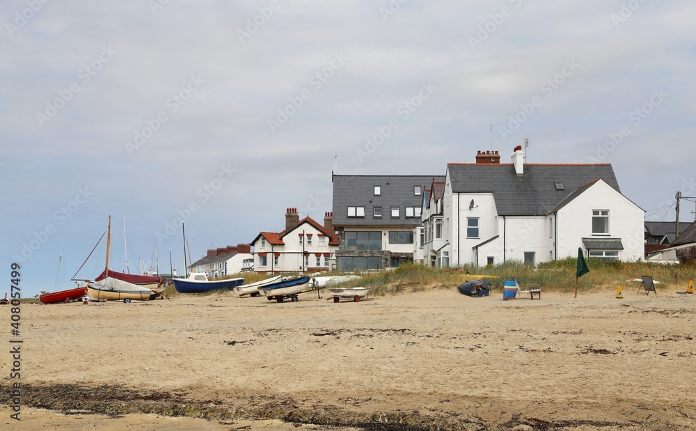 British beach side houses and boats on the sand at Rhosneigr, Isle of Anglesey, Wales, UK. 