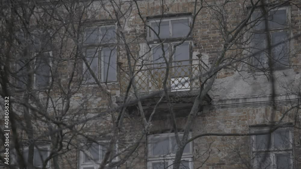 Camera panning on an old Jewish Ghetto building, revealing old bricks, peeling plaster, and balconies, taken through bare winter branches. a 4K (Sony S-Log) video clip, Warsaw, Poland. Camera panning on an old Jewish Ghetto building, revealing old bricks, peeling plaster, and balconies, taken through bare winter branches. a 4K (Sony S-Log) video clip, Warsaw, Poland.