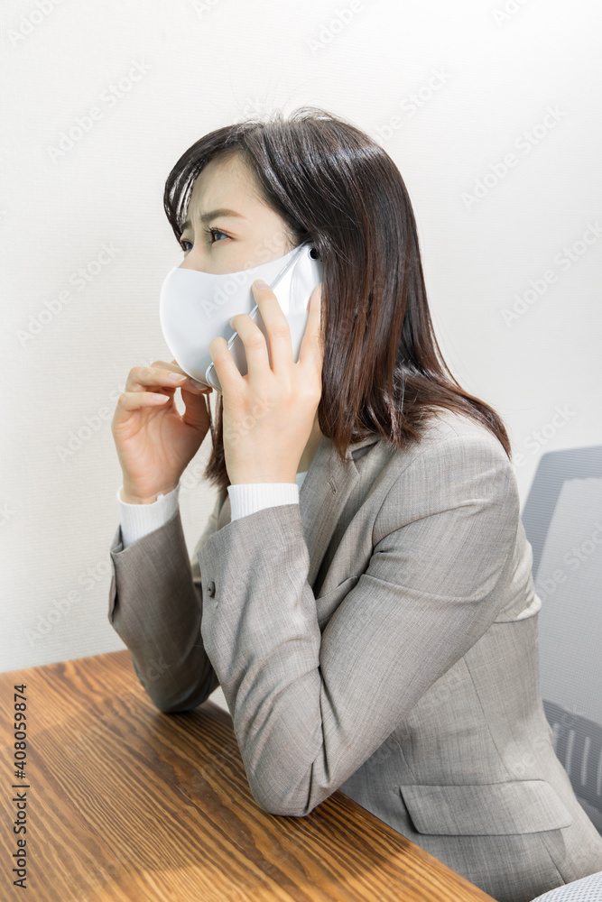 Woman wearing a mask worried about work phone Woman wearing a mask worried about work phone