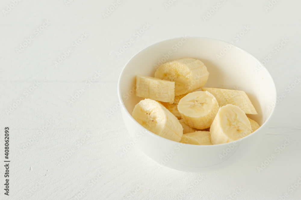 Ripe bananas cut in white bowl for eating. Healthy snack or breakfast concept Ripe bananas cut in white bowl for eating. Healthy snack or breakfast concept