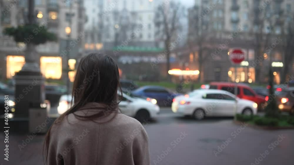 Young beautiful girl in a gray coat walking down the street Young beautiful girl in a gray coat walking down the street