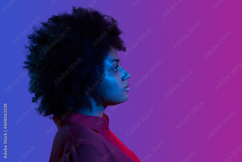 Profile closeup portrait of african woman looking forward, neon light studio portrait Profile closeup portrait of african woman looking forward, neon light studio portrait