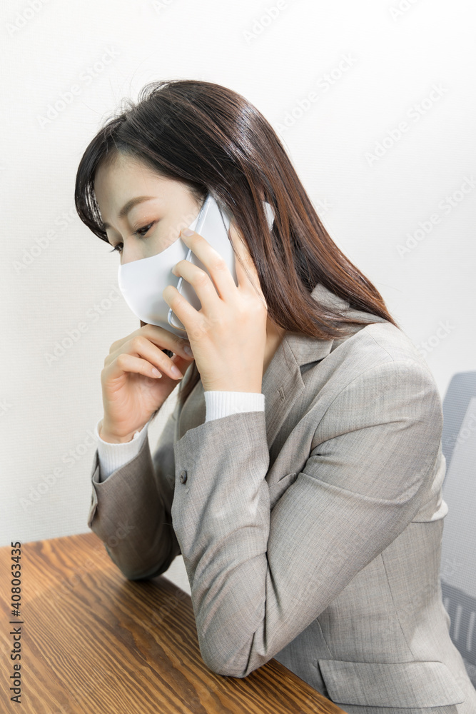 Woman wearing a mask worried about work phone Woman wearing a mask worried about work phone