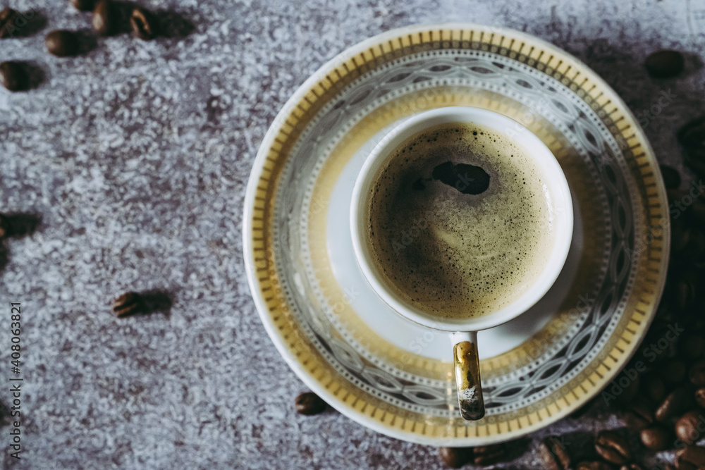 Tasse de café expresso avec des grains de café sur un fond texturé gris Tasse de café expresso avec des grains de café sur un fond texturé gris