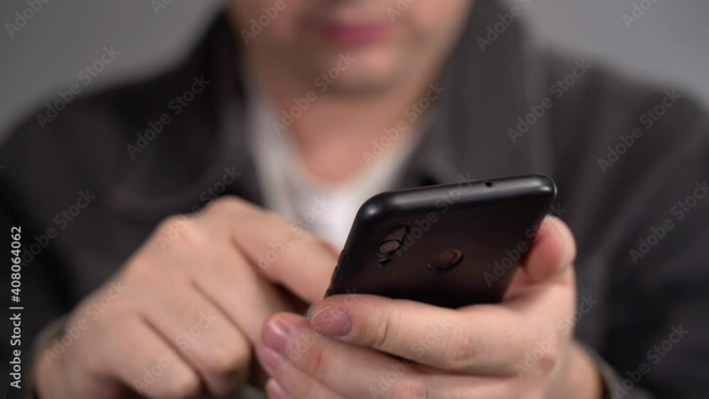 The Man Uses a Smartphone. Flip through Pictures on Smartphone. Slow motion The Man Uses a Smartphone. Flip through Pictures on Smartphone. Slow motion