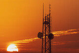 Communication tower against sunset background