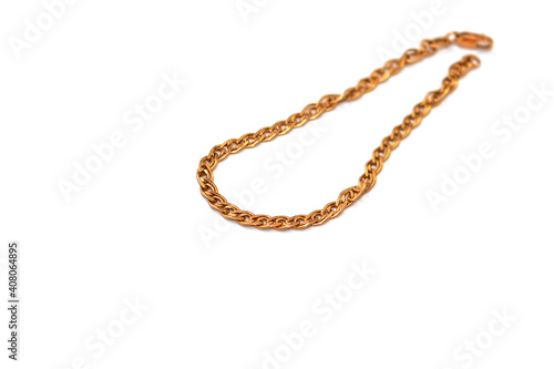 A gold chain for decorating a woman's hand lies on a white background