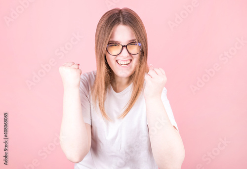 Beautiful woman wearing glasses is happy and excited expressing a victory gesture. Successful and triumphant victory, triumphant, open photo
