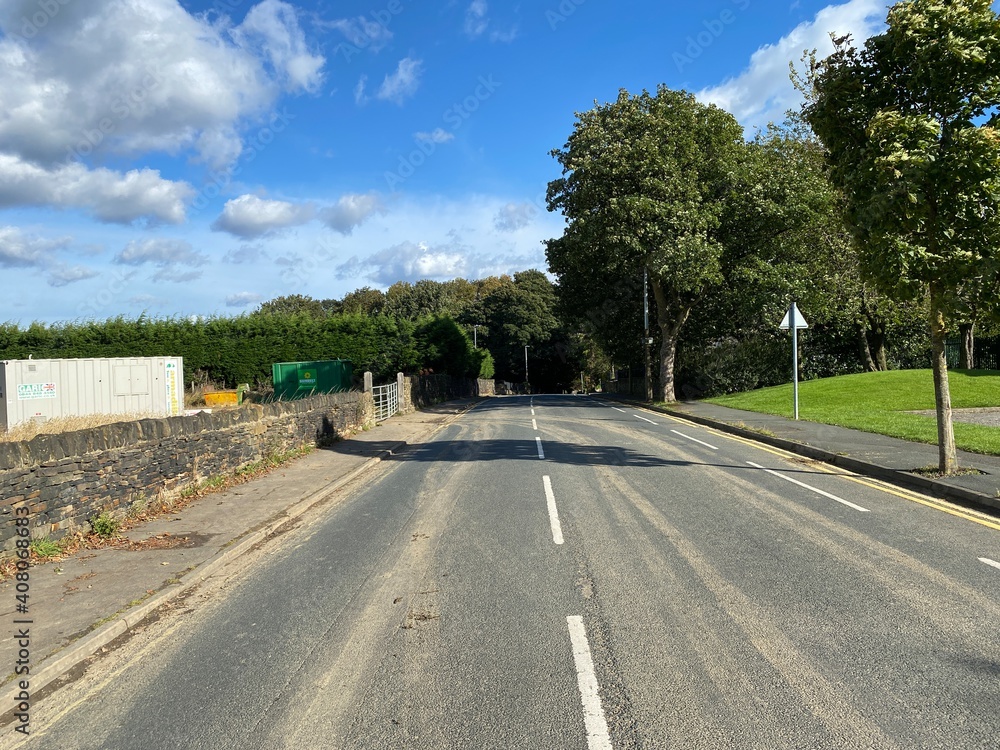 Fototapeta premium View along, Whitechapel Road, with outbuildings and trees in, Cleckheaton, Yorkshire, UK