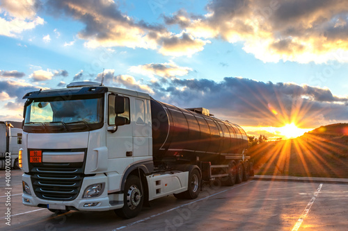 Tank truck with dangerous goods parked and the evening sun setting behind the mountains.