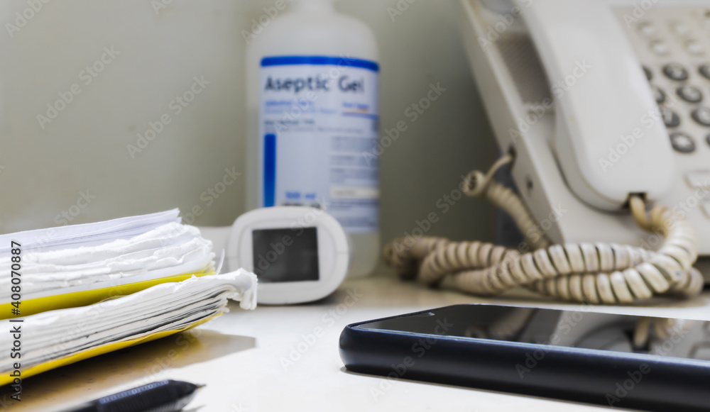 Work by always maintaining cleanliness concept stock image. Thermometer,phone,mobilephone,hand sanitizer and paper on the desk.equipment of office business. Work by always maintaining cleanliness concept stock image. Thermometer,phone,mobilephone,hand sanitizer and paper on the desk.equipment of office business.