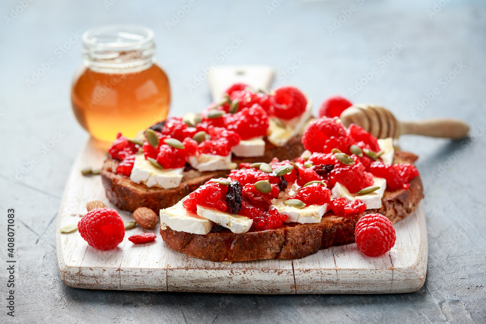Raspberry and brie sourdough bread toast with pumpkin seeds and drizzled with honey Raspberry and brie sourdough bread toast with pumpkin seeds and drizzled with honey