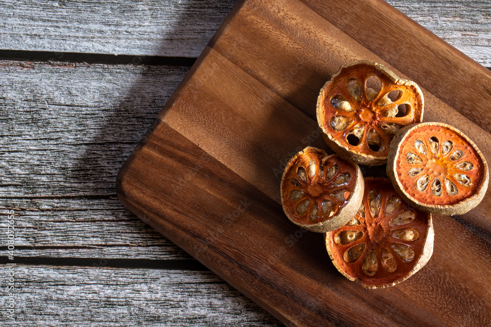 Dried quince fruit thinly on a wooden cutting board. Dried quince fruit thinly on a wooden cutting board.