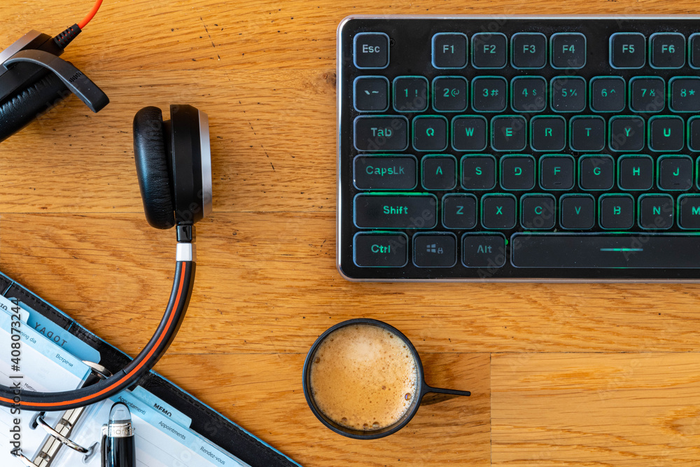Smart working desktop with laptop, headset, agenda and coffee Smart working desktop with laptop, headset, agenda and coffee