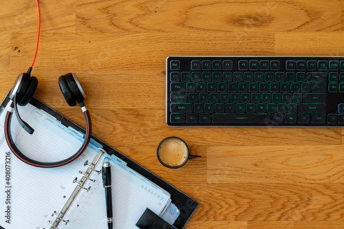 Smart working desktop with laptop, headset, agenda and coffee